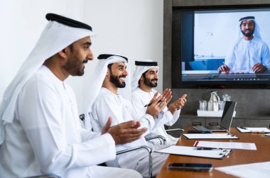 İş anlaşması için emirati kandura giyen Arap işadamları, Orta Doğu 'da uluslararası bir şirkette çalışan orta doğulu kurumsal iş adamları grubu.