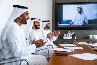 İş anlaşması için emirati kandura giyen Arap işadamları, Orta Doğu 'da uluslararası bir şirkette çalışan orta doğulu kurumsal iş adamları grubu.