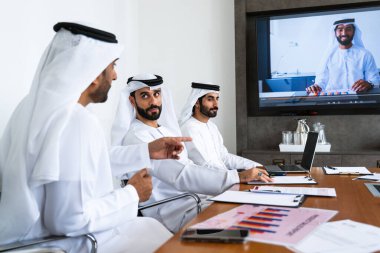 İş anlaşması için emirati kandura giyen Arap işadamları, Orta Doğu 'da uluslararası bir şirkette çalışan orta doğulu kurumsal iş adamları grubu.