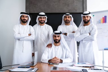 İş anlaşması için emirati kandura giyen Arap işadamları, Orta Doğu 'da uluslararası bir şirkette çalışan orta doğulu kurumsal iş adamları grubu.