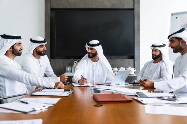 İş anlaşması için emirati kandura giyen Arap işadamları, Orta Doğu 'da uluslararası bir şirkette çalışan orta doğulu kurumsal iş adamları grubu.