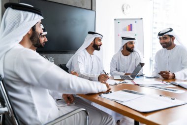 İş anlaşması için emirati kandura giyen Arap işadamları, Orta Doğu 'da uluslararası bir şirkette çalışan orta doğulu kurumsal iş adamları grubu.