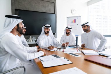 İş anlaşması için emirati kandura giyen Arap işadamları, Orta Doğu 'da uluslararası bir şirkette çalışan orta doğulu kurumsal iş adamları grubu.