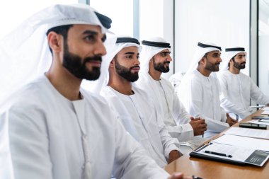 İş anlaşması için emirati kandura giyen Arap işadamları, Orta Doğu 'da uluslararası bir şirkette çalışan orta doğulu kurumsal iş adamları grubu.