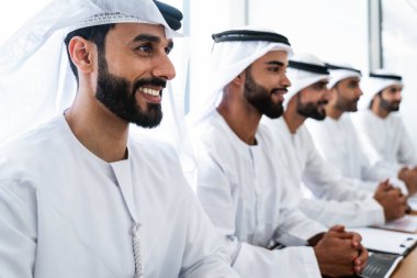 İş anlaşması için emirati kandura giyen Arap işadamları, Orta Doğu 'da uluslararası bir şirkette çalışan orta doğulu kurumsal iş adamları grubu.