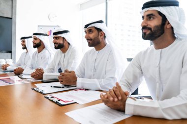 İş anlaşması için emirati kandura giyen Arap işadamları, Orta Doğu 'da uluslararası bir şirkette çalışan orta doğulu kurumsal iş adamları grubu.