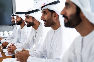 İş anlaşması için emirati kandura giyen Arap işadamları, Orta Doğu 'da uluslararası bir şirkette çalışan orta doğulu kurumsal iş adamları grubu.
