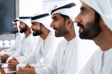 İş anlaşması için emirati kandura giyen Arap işadamları, Orta Doğu 'da uluslararası bir şirkette çalışan orta doğulu kurumsal iş adamları grubu.
