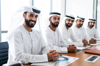 İş anlaşması için emirati kandura giyen Arap işadamları, Orta Doğu 'da uluslararası bir şirkette çalışan orta doğulu kurumsal iş adamları grubu.