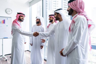 Emirati ve Suudi kandura giyen Arap işadamları iş anlaşması için Orta Doğu 'da uluslararası bir şirkette çalışan kurumsal bir iş grubu olan