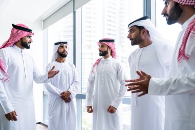 Emirati ve Suudi kandura giyen Arap işadamları iş anlaşması için Orta Doğu 'da uluslararası bir şirkette çalışan kurumsal bir iş grubu olan