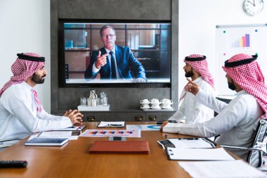 İş anlaşması için Suudi kandura giyen Arap işadamları, Orta Doğu 'da uluslararası bir şirkette çalışan orta doğulu kurumsal iş adamları grubu.