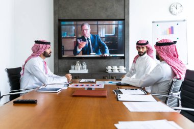 İş anlaşması için Suudi kandura giyen Arap işadamları, Orta Doğu 'da uluslararası bir şirkette çalışan orta doğulu kurumsal iş adamları grubu.