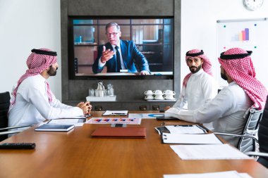 İş anlaşması için Suudi kandura giyen Arap işadamları, Orta Doğu 'da uluslararası bir şirkette çalışan orta doğulu kurumsal iş adamları grubu.