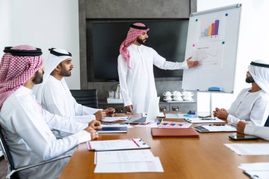 Emirati ve Suudi kandura giyen Arap işadamları iş anlaşması için Orta Doğu 'da uluslararası bir şirkette çalışan kurumsal bir iş grubu olan