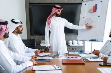 Emirati ve Suudi kandura giyen Arap işadamları iş anlaşması için Orta Doğu 'da uluslararası bir şirkette çalışan kurumsal bir iş grubu olan