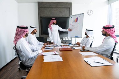 Emirati ve Suudi kandura giyen Arap işadamları iş anlaşması için Orta Doğu 'da uluslararası bir şirkette çalışan kurumsal bir iş grubu olan