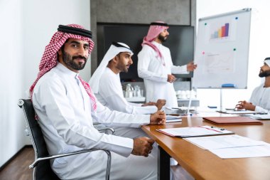 Emirati ve Suudi kandura giyen Arap işadamları iş anlaşması için Orta Doğu 'da uluslararası bir şirkette çalışan kurumsal bir iş grubu olan