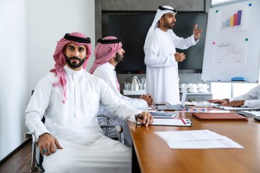 Emirati ve Suudi kandura giyen Arap işadamları iş anlaşması için Orta Doğu 'da uluslararası bir şirkette çalışan kurumsal bir iş grubu olan