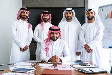 Emirati ve Suudi kandura giyen Arap işadamları iş anlaşması için Orta Doğu 'da uluslararası bir şirkette çalışan kurumsal bir iş grubu olan