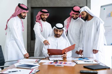 Emirati ve Suudi kandura giyen Arap işadamları iş anlaşması için Orta Doğu 'da uluslararası bir şirkette çalışan kurumsal bir iş grubu olan