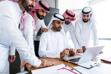 Emirati ve Suudi kandura giyen Arap işadamları iş anlaşması için Orta Doğu 'da uluslararası bir şirkette çalışan kurumsal bir iş grubu olan