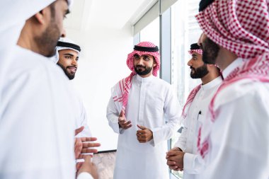 Emirati ve Suudi kandura giyen Arap işadamları iş anlaşması için Orta Doğu 'da uluslararası bir şirkette çalışan kurumsal bir iş grubu olan