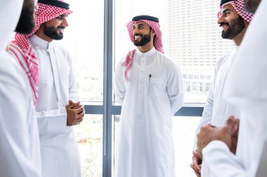 Emirati ve Suudi kandura giyen Arap işadamları iş anlaşması için Orta Doğu 'da uluslararası bir şirkette çalışan kurumsal bir iş grubu olan