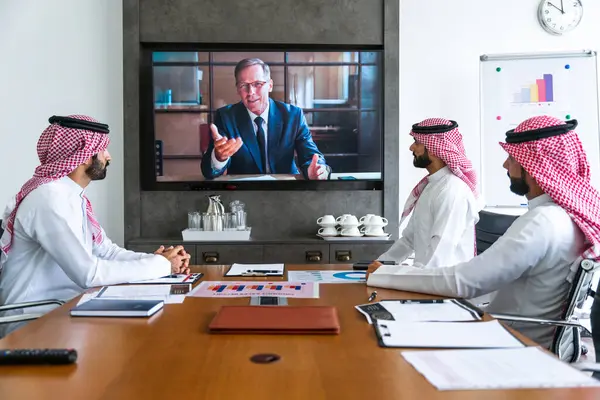 İş anlaşması için Suudi kandura giyen Arap işadamları, Orta Doğu 'da uluslararası bir şirkette çalışan orta doğulu kurumsal iş adamları grubu.