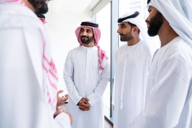 Emirati ve Suudi kandura giyen Arap işadamları iş anlaşması için Orta Doğu 'da uluslararası bir şirkette çalışan kurumsal bir iş grubu olan