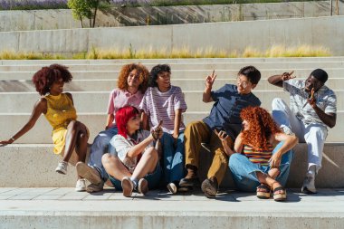 Çok ırklı bir grup genç arkadaş buluşuyor ve dışarıda eğleniyorlar- çok ırklı mutlu ve şık genç öğrenciler şehirde kaynaşıyor, gençlik kavramları, gençlerin yaşam tarzı ve çeşitliliği