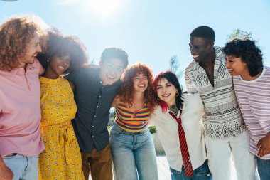 Çok ırklı bir grup genç arkadaş buluşuyor ve dışarıda eğleniyorlar- çok ırklı mutlu ve şık genç öğrenciler şehirde kaynaşıyor, gençlik kavramları, gençlerin yaşam tarzı ve çeşitliliği