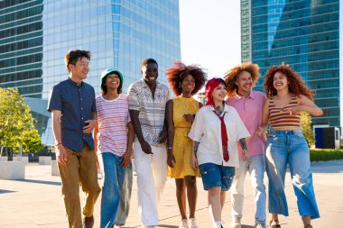 Çok ırklı bir grup genç arkadaş buluşuyor ve dışarıda eğleniyorlar- çok ırklı mutlu ve şık genç öğrenciler şehirde kaynaşıyor, gençlik kavramları, gençlerin yaşam tarzı ve çeşitliliği