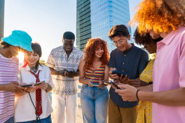 Çok ırklı bir grup genç arkadaş buluşuyor ve dışarıda eğleniyorlar- çok ırklı mutlu ve şık genç öğrenciler şehirde kaynaşıyor, gençlik kavramları, gençlerin yaşam tarzı ve çeşitliliği