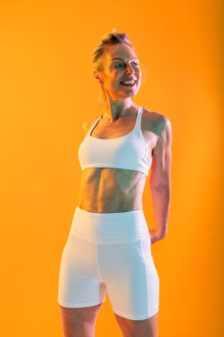 Spor kıyafetleri giyen, spor yapan olgun bir kadın. Sportif, olgun bir kadın. Enerjik bir geçmişe sahip, güçlü, hayat dolu ve aktif bir yaşam tarzı olan bir kadın.