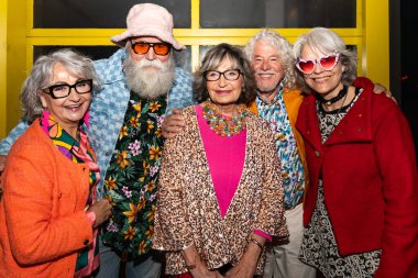 Süslü elbiseli mutlu son sınıf arkadaşları gecenin bir yarısı şehir sokaklarında parti veriyor. Şık kıyafetler giyen ve dışarıda eğlenen neşeli yaşlı insanlar.