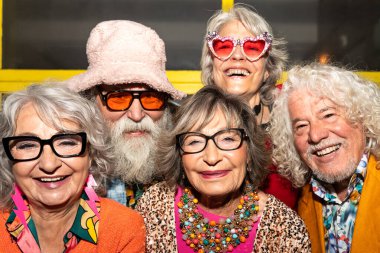 Süslü elbiseli mutlu son sınıf arkadaşları gecenin bir yarısı şehir sokaklarında parti veriyor. Şık kıyafetler giyen ve dışarıda eğlenen neşeli yaşlı insanlar.