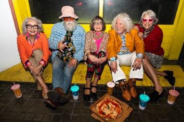 Süslü elbiseli mutlu son sınıf arkadaşları gecenin bir yarısı şehir sokaklarında parti veriyor. Şık kıyafetler giyen ve dışarıda eğlenen neşeli yaşlı insanlar.