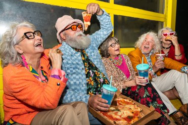 Süslü elbiseli mutlu son sınıf arkadaşları gecenin bir yarısı şehir sokaklarında parti veriyor. Şık kıyafetler giyen ve dışarıda eğlenen neşeli yaşlı insanlar.