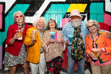 Süslü elbiseli mutlu son sınıf arkadaşları gecenin bir yarısı şehir sokaklarında parti veriyor. Şık kıyafetler giyen ve dışarıda eğlenen neşeli yaşlı insanlar.