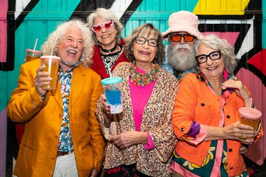 Süslü elbiseli mutlu son sınıf arkadaşları gecenin bir yarısı şehir sokaklarında parti veriyor. Şık kıyafetler giyen ve dışarıda eğlenen neşeli yaşlı insanlar.