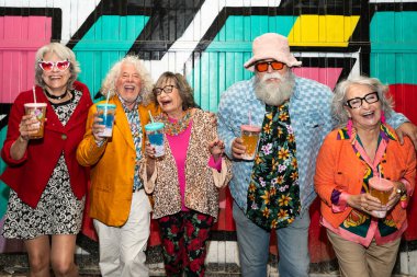 Süslü elbiseli mutlu son sınıf arkadaşları gecenin bir yarısı şehir sokaklarında parti veriyor. Şık kıyafetler giyen ve dışarıda eğlenen neşeli yaşlı insanlar.