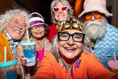 Süslü elbiseli mutlu son sınıf arkadaşları gecenin bir yarısı şehir sokaklarında parti veriyor. Şık kıyafetler giyen ve dışarıda eğlenen neşeli yaşlı insanlar.