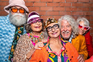 Süslü elbiseli mutlu son sınıf arkadaşları gecenin bir yarısı şehir sokaklarında parti veriyor. Şık kıyafetler giyen ve dışarıda eğlenen neşeli yaşlı insanlar.