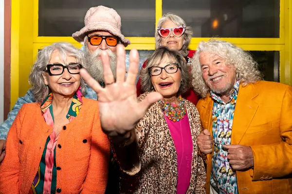 Süslü elbiseli mutlu son sınıf arkadaşları gecenin bir yarısı şehir sokaklarında parti veriyor. Şık kıyafetler giyen ve dışarıda eğlenen neşeli yaşlı insanlar.