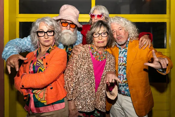 Süslü elbiseli mutlu son sınıf arkadaşları gecenin bir yarısı şehir sokaklarında parti veriyor. Şık kıyafetler giyen ve dışarıda eğlenen neşeli yaşlı insanlar.