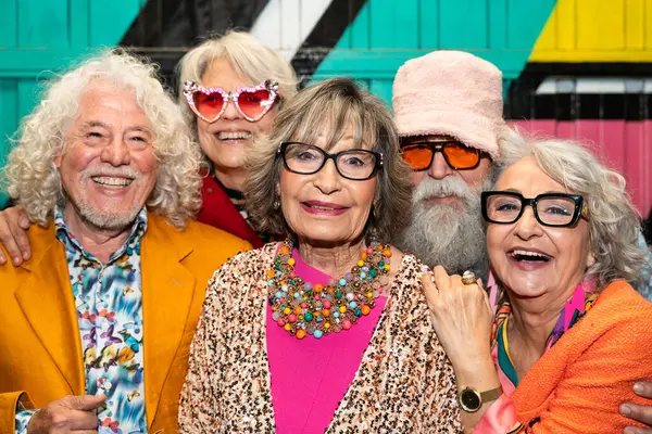 Süslü elbiseli mutlu son sınıf arkadaşları gecenin bir yarısı şehir sokaklarında parti veriyor. Şık kıyafetler giyen ve dışarıda eğlenen neşeli yaşlı insanlar.