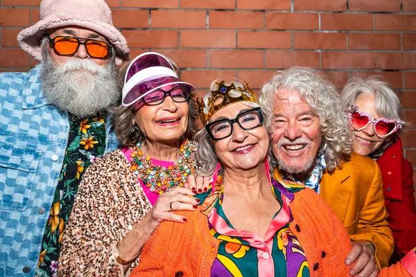 Süslü elbiseli mutlu son sınıf arkadaşları gecenin bir yarısı şehir sokaklarında parti veriyor. Şık kıyafetler giyen ve dışarıda eğlenen neşeli yaşlı insanlar.