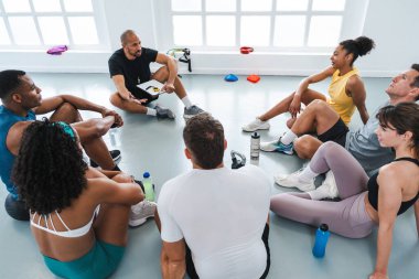 Spor salonunda spor yapan çok ırklı bir grup sporcu spor salonunda çeşitli sporcular spor salonunda toplanıyor.