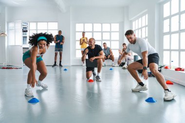 Spor salonunda egzersiz yapan çok ırklı bir grup sporcu. Spor salonunda çalışan iki sporcu.